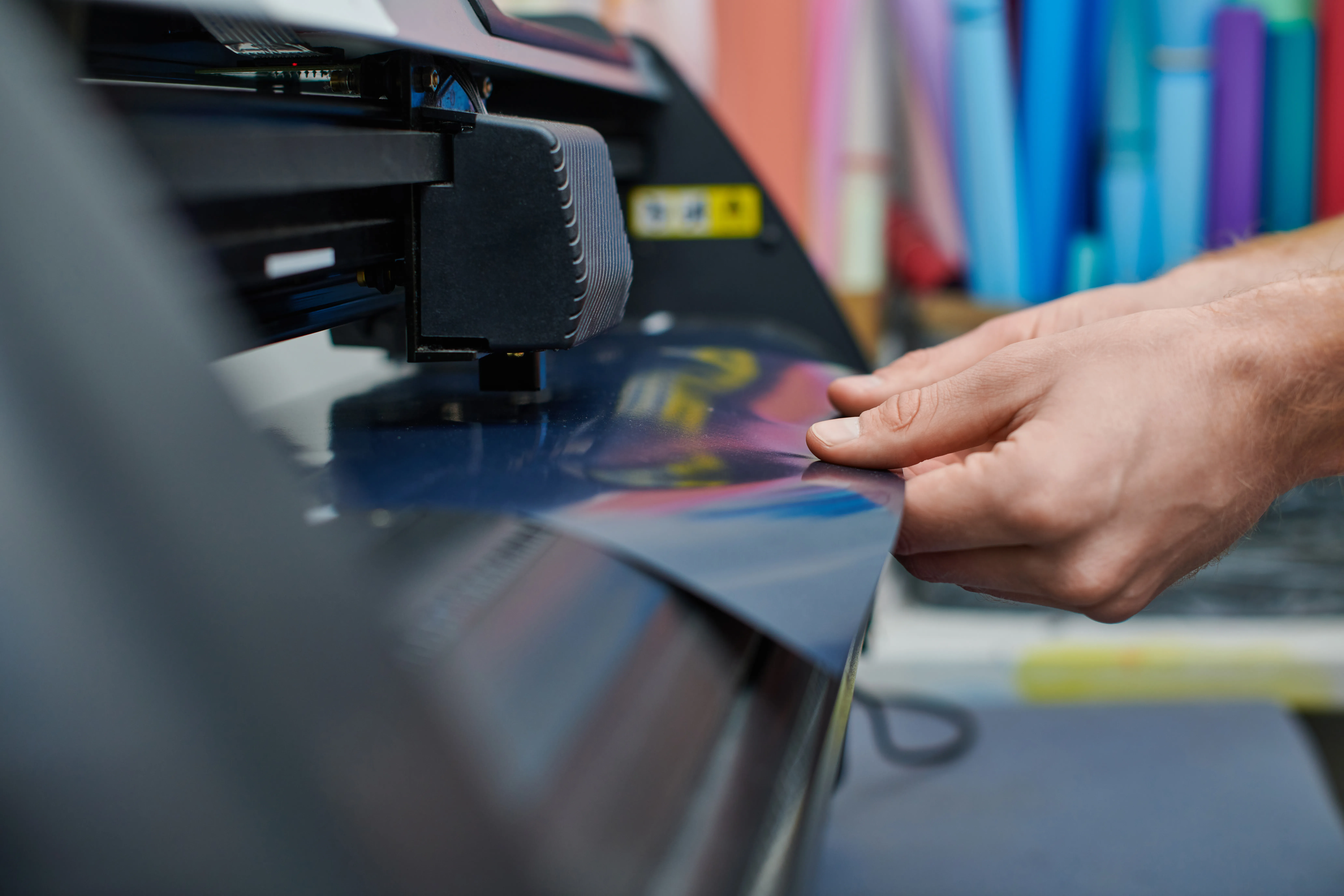  Imagen de manos de una persona que está aprendiendo impresión offset mientras realiza trabajos de impresión